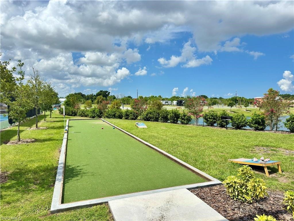 Bocce ball court with artificial turf, bordered by concrete and landscaping