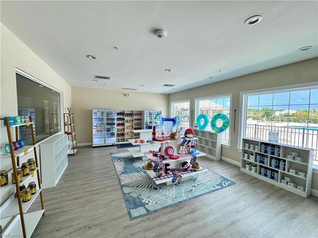 Open retail space featuring wood-finish flooring, recessed lighting, and multiple windows