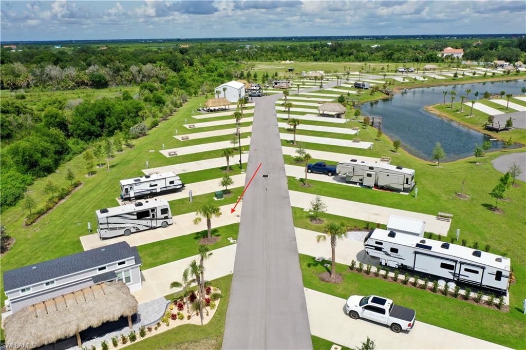 Paved road access with multiple RV pads, manicured green spaces, and a prominent water feature
