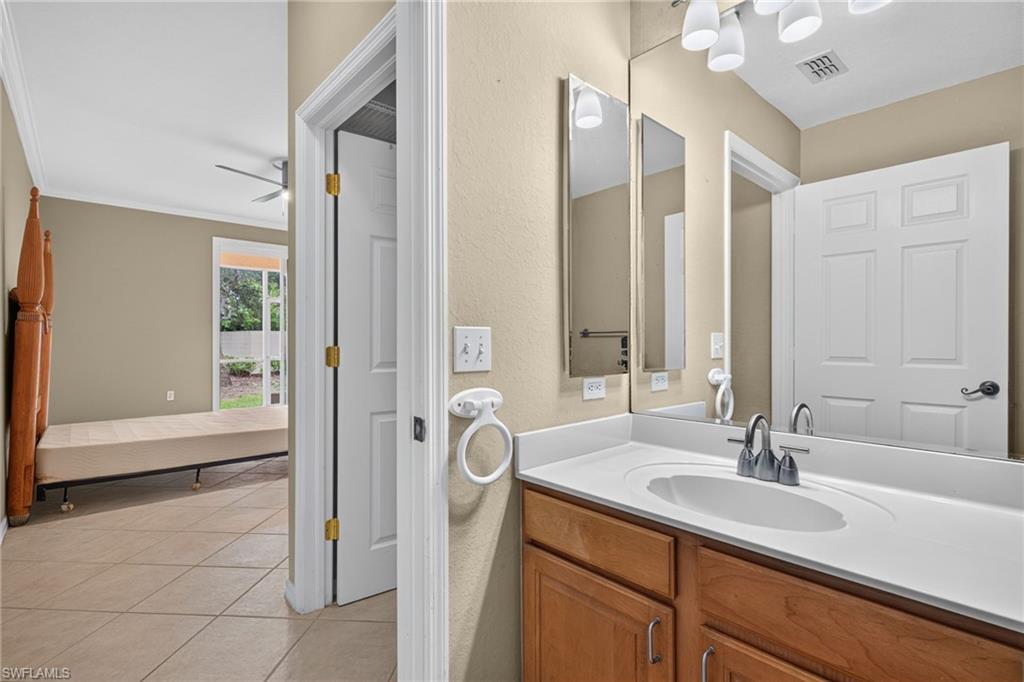 Bathroom vanity with a single basin, integrated countertop, wood-finish cabinetry, and an expansive wall-mounted mirror