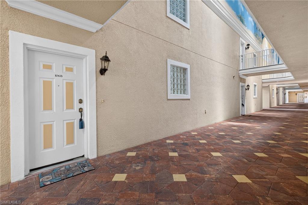 Welcoming entry featuring a six-panel white door with glass inserts and sidelights, complemented by a wall-mounted lantern fixture