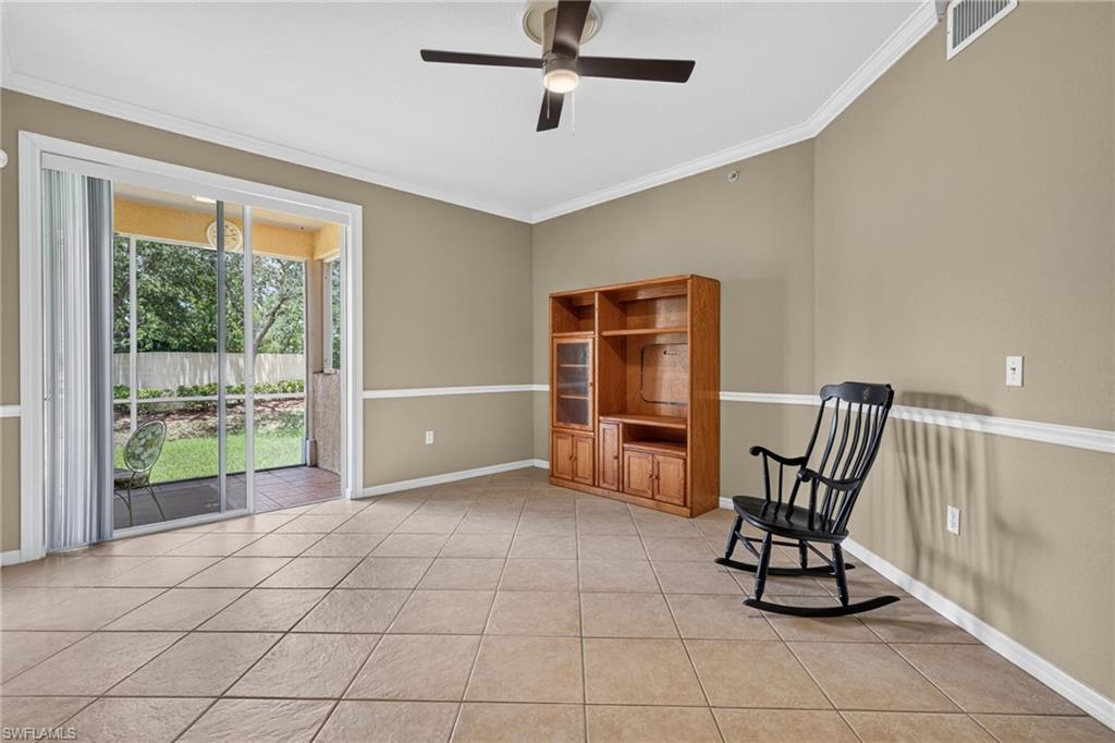 Spacious room featuring tile flooring, crown molding, a ceiling fan, and sliding glass doors that open to a screened porch