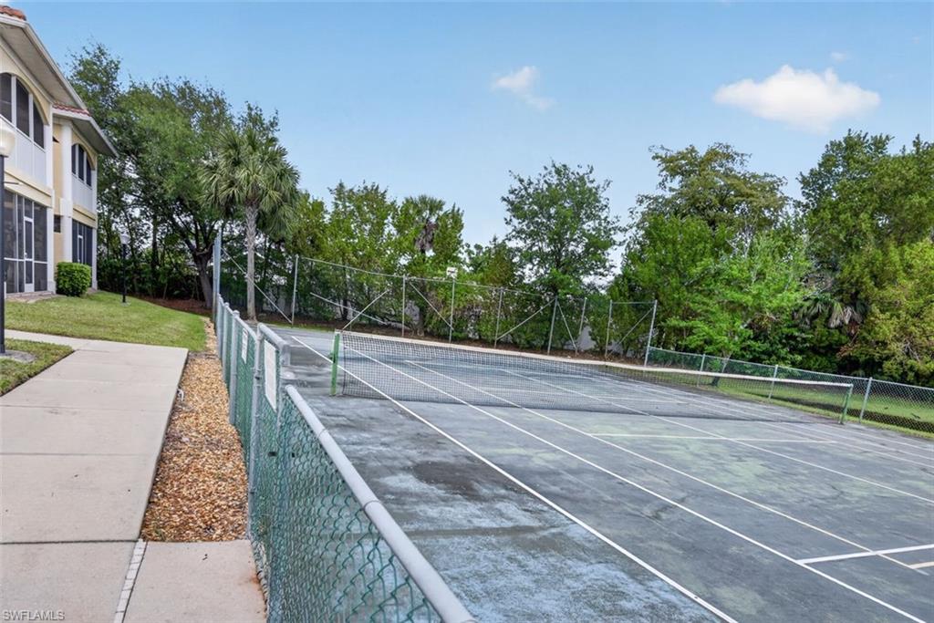 On-site tennis court with chain-link fencing