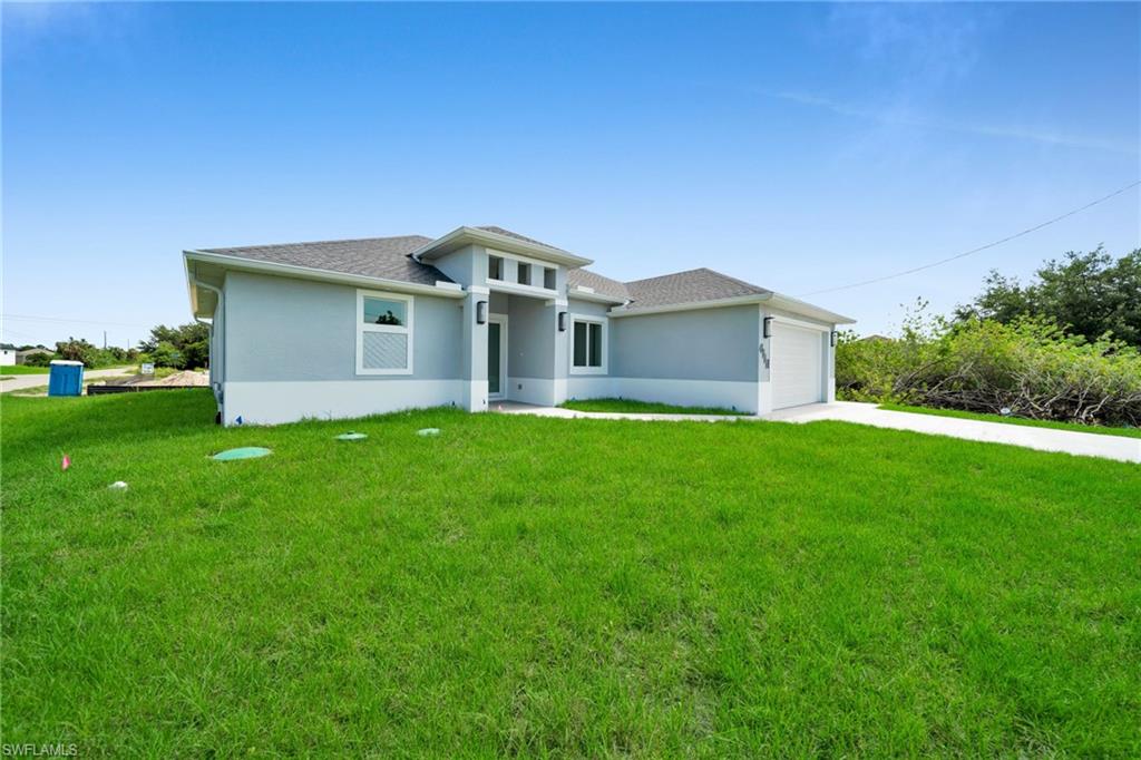 Contemporary architectural style with a light gray facade, dark shingle roof, integrated garage, and a concrete driveway