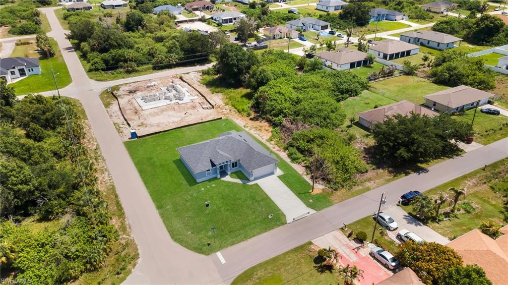 Single-story residence featuring a paved driveway, attached garage, and manicured lawn