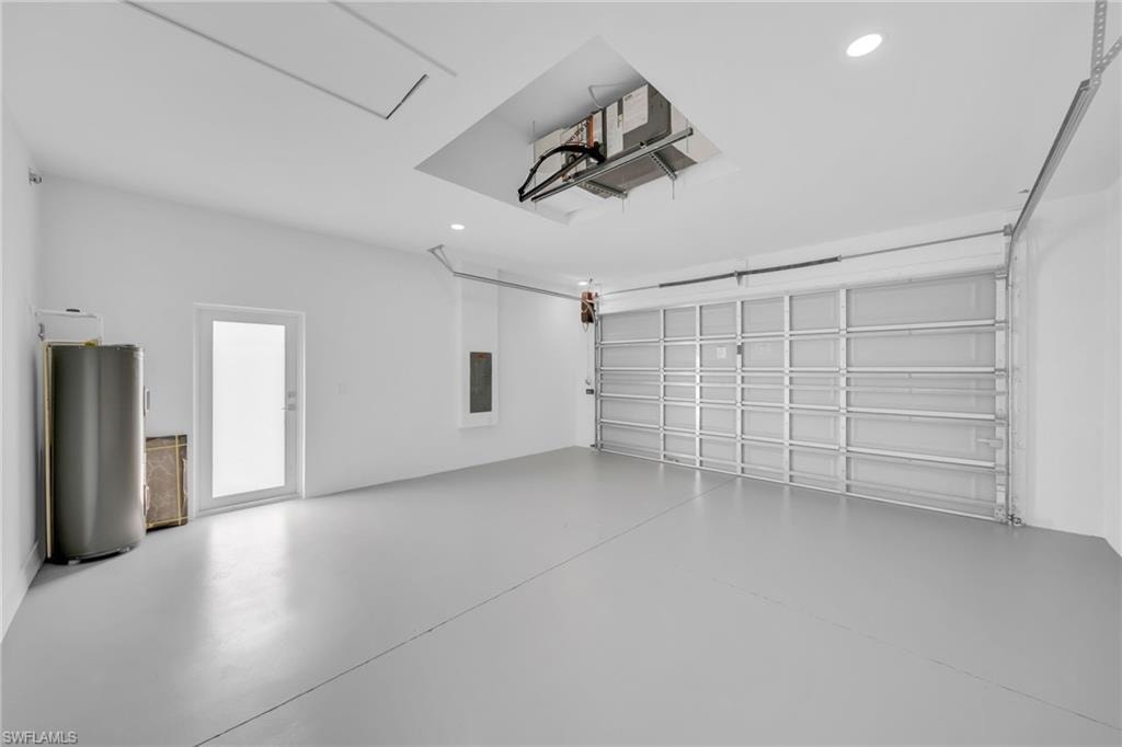 Spacious garage featuring a light gray floor, white painted walls, and a large overhead door