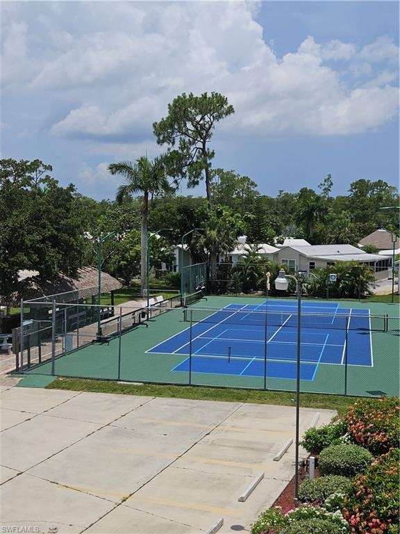 Tennis & Pickle Ball courts with blue playing surface and green surrounds, fenced perimeter, and adjacent concrete paving