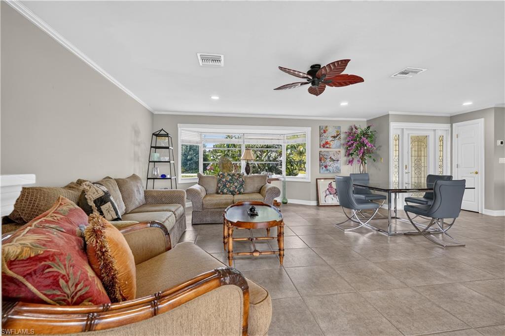 Recessed lighting, crown molding, bay window, tile flooring, and a ceiling fan