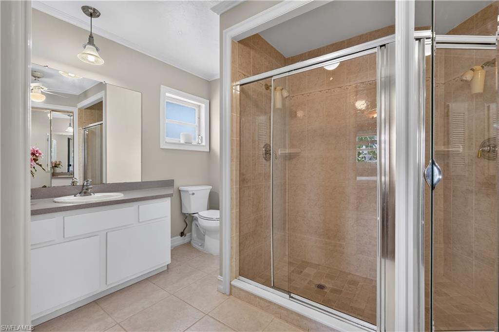 White vanity with a rectangular sink and gray countertop, complemented by a large wall mirror