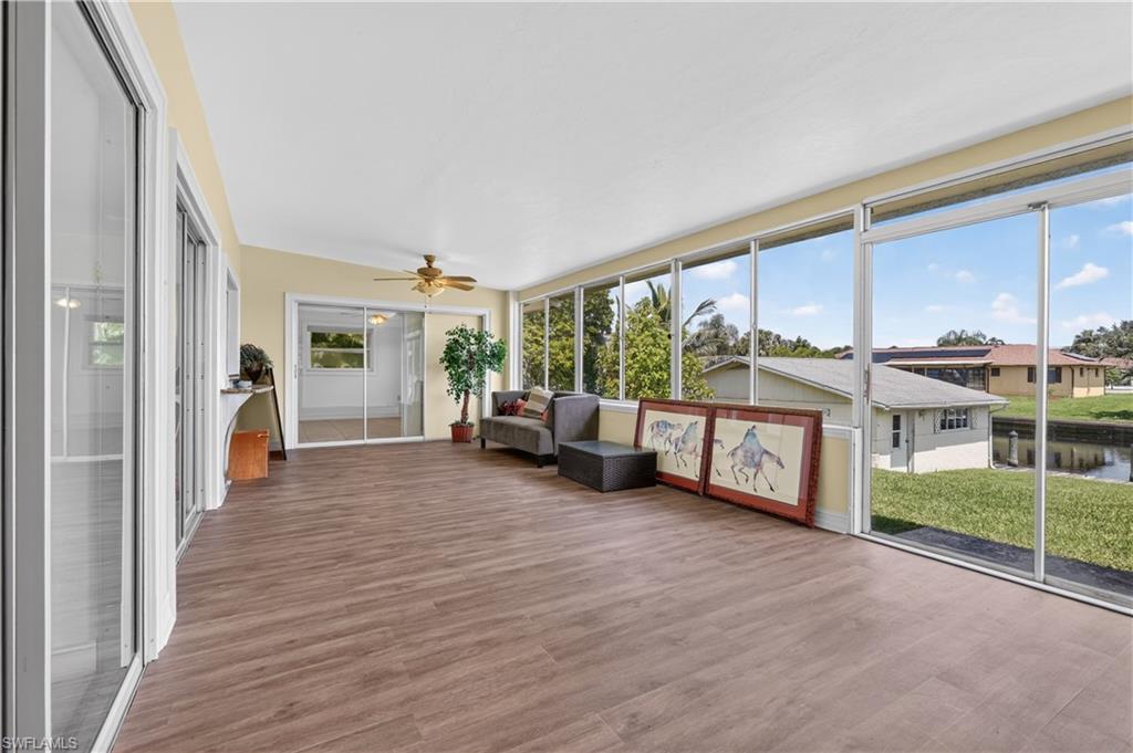 Expansive sunroom with wood-finish flooring, a vaulted ceiling, and sliding glass doors