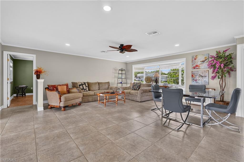 Expansive open-concept living space with large tile flooring, a bay window, and recessed lighting