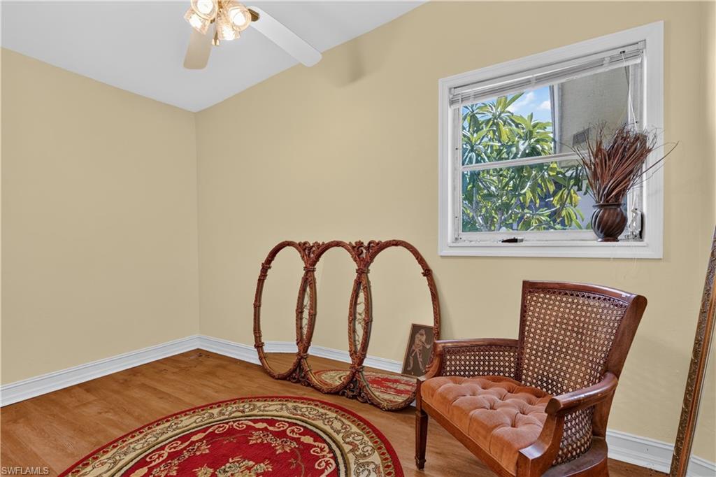 Wood-finish flooring, white trim, and a ceiling fan with integrated lighting