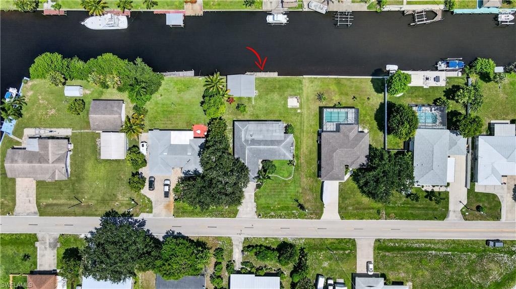Waterfront property with canal access, private dock, and a spacious green lawn