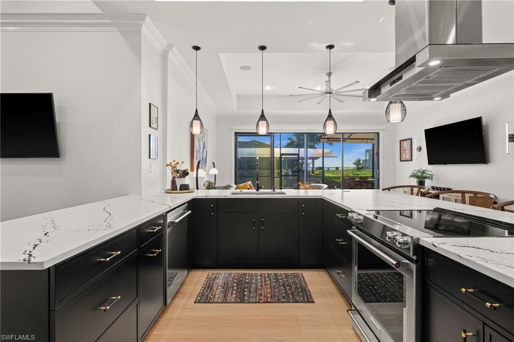 Dramatic U shaped kitchen overlooks the pool and family room