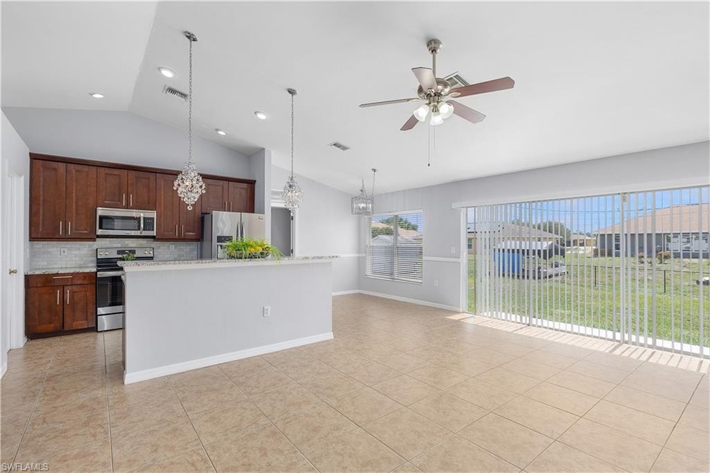 Open-concept living and dining area featuring tile flooring, recessed lighting, and a ceiling fan