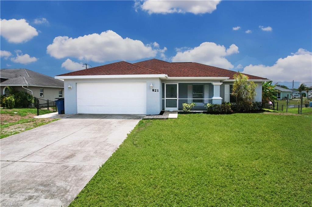 Single-story residence featuring a two-car garage, screened entry, and a well-maintained lawn