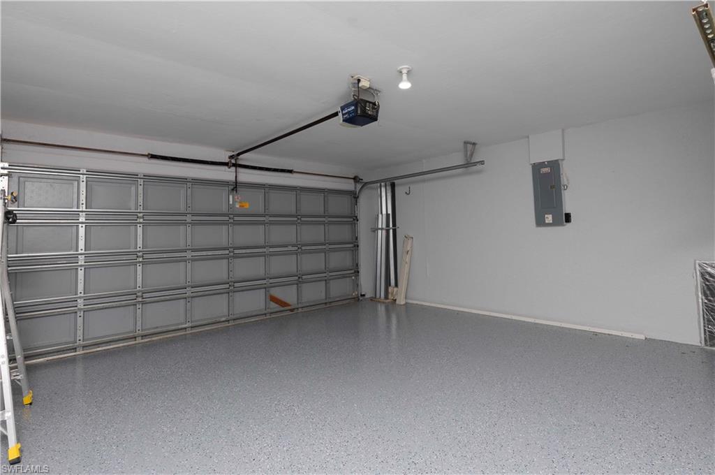 Garage featuring a textured concrete floor, paneled garage door, and recessed lighting