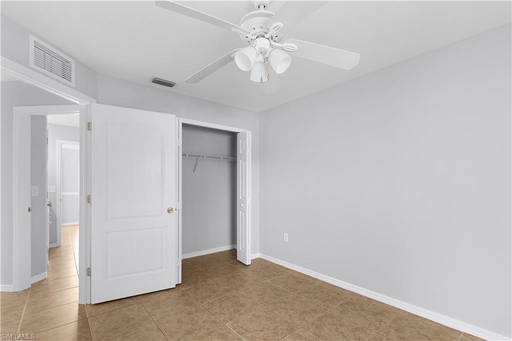 Tile flooring, ceiling fan with integrated lighting, bi-fold closet doors, and light gray wall paint
