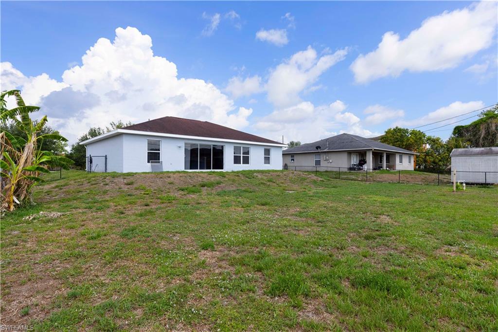 Expansive rear yard with a gentle slope and partial fencing