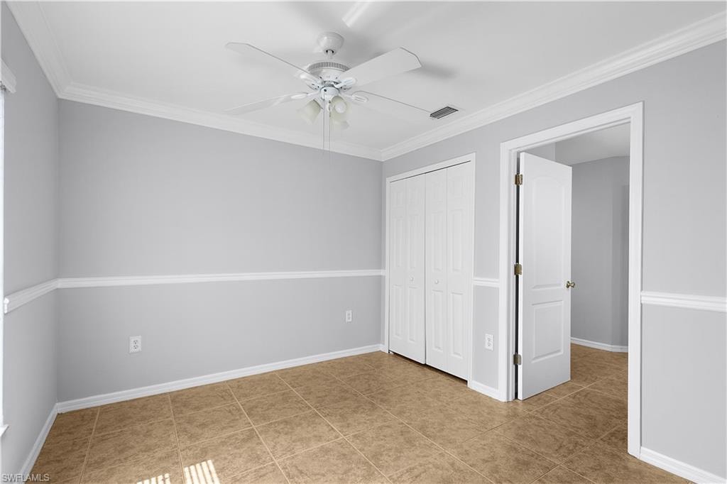 Spacious secondary bedroom featuring neutral paint tones, decorative chair rail molding, and wood-finish flooring