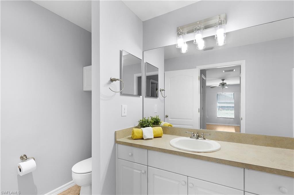 Vanity with an integrated sink, brushed nickel faucet, and a large mirror
