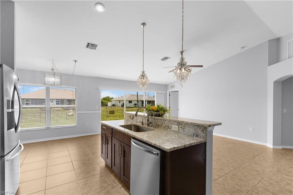 Kitchen island featuring a double-basin sink, stainless steel dishwasher, and granite countertop