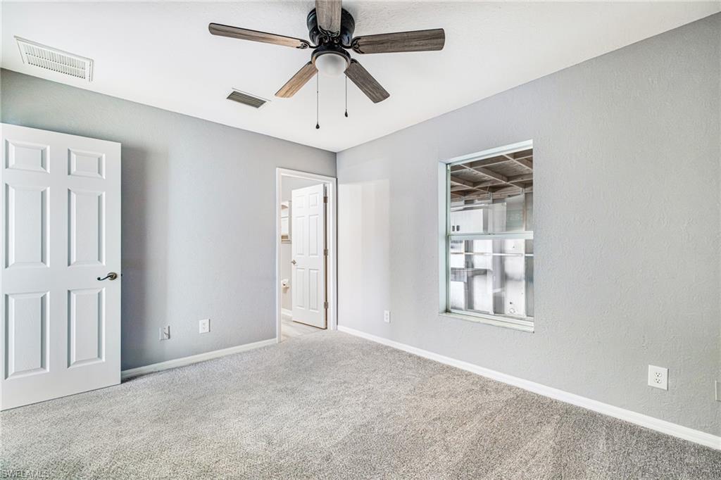 Primary bedroom with ceiling fan, private bathroom and next to the home workshop.