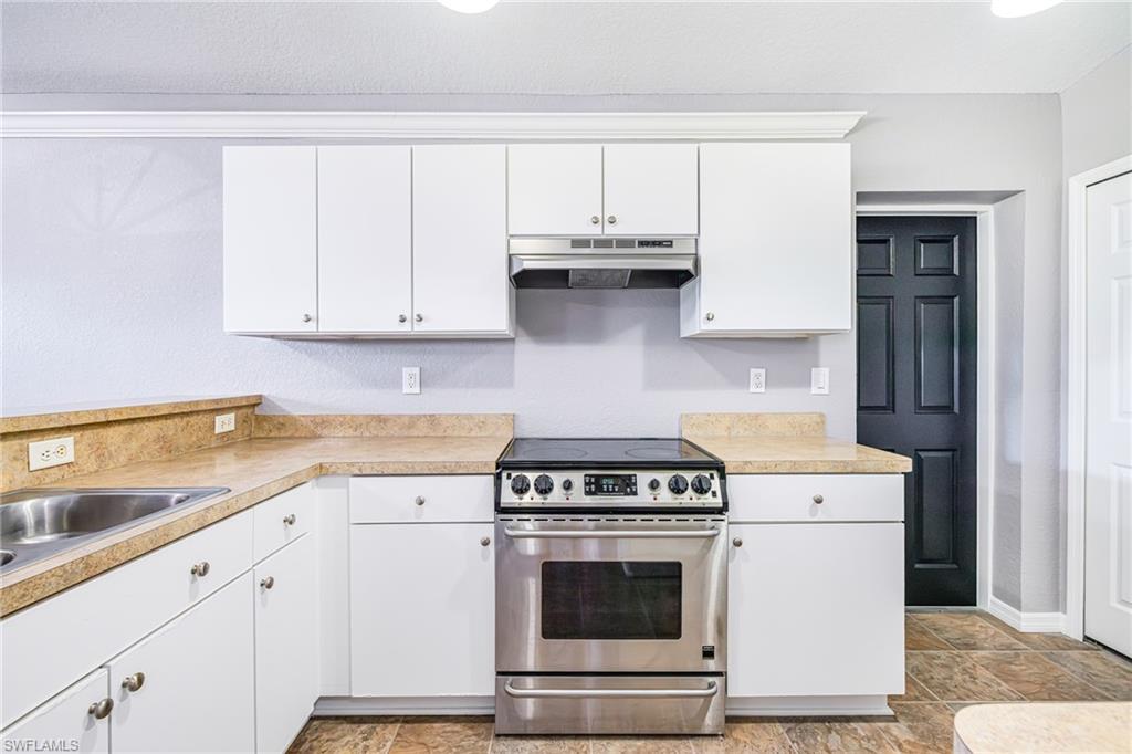 Kitchen featuring white cabinets and stainless steel stove