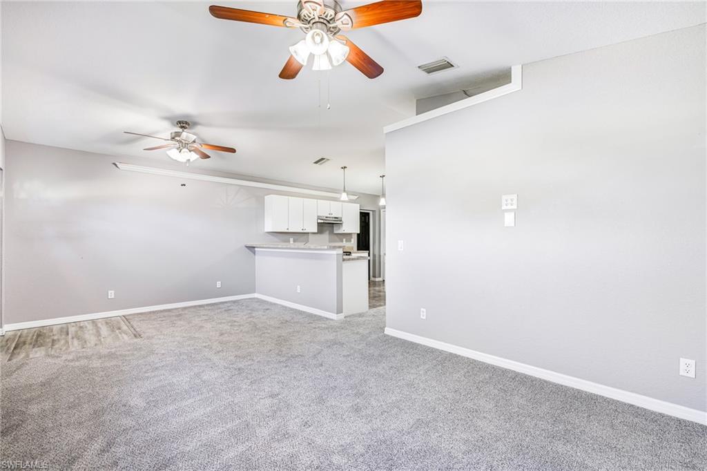 Living room with carpet and ceiling fans