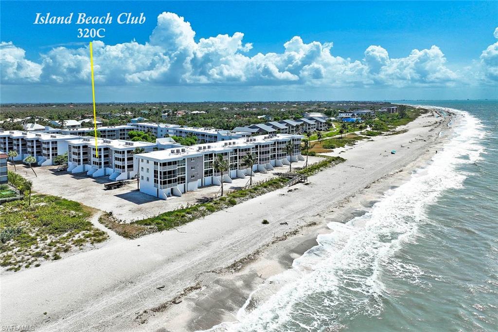 Island Beach Club 320C features modern coastal architecture with multi-story residential construction, direct beachfront positioning, and expansive sandy beach with Atlantic Ocean frontage