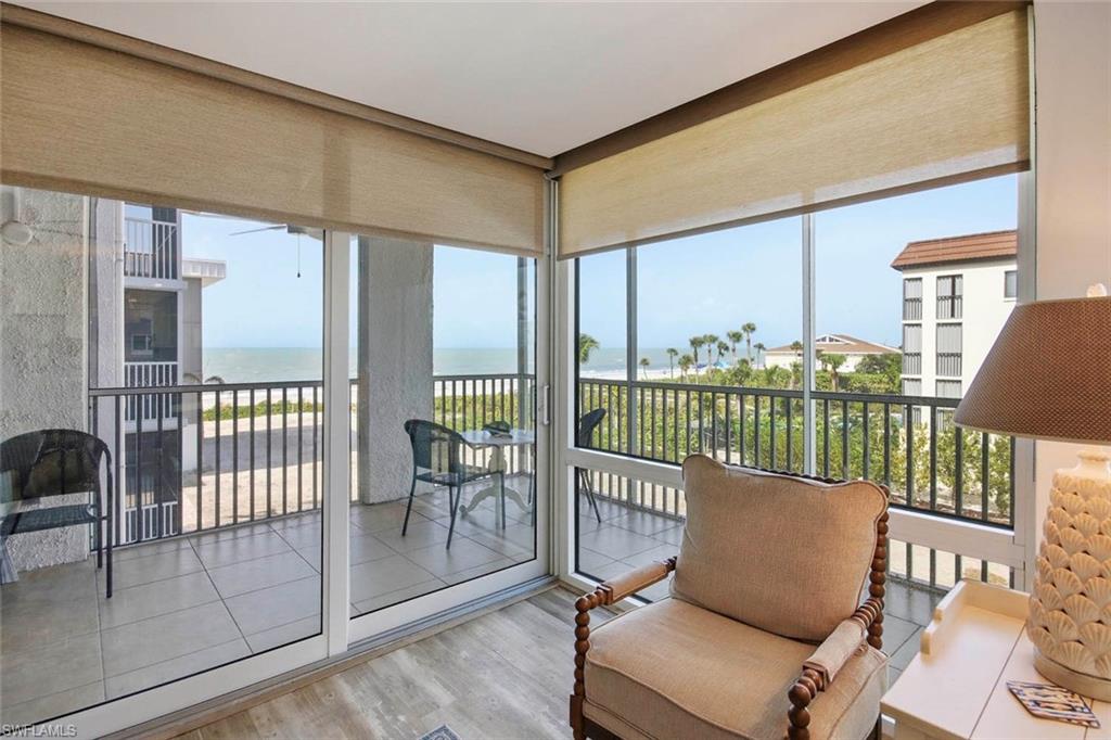 Sliding glass doors with direct water scenery, sun shades, and tile flooring on the balcony