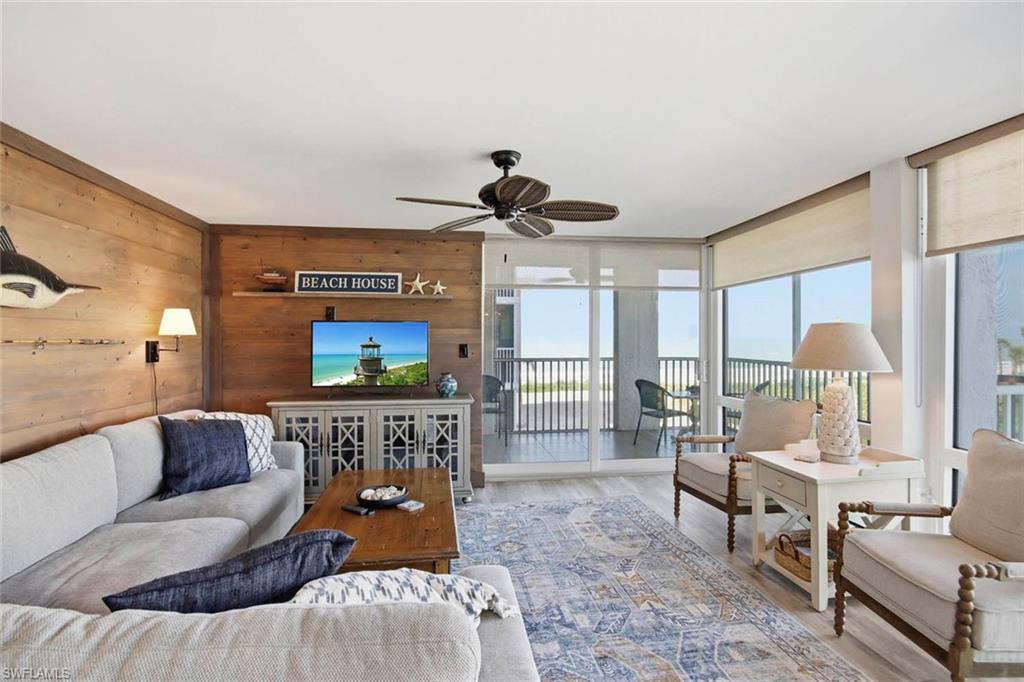 Wood-finish accent walls, ceiling fan, wood-finish flooring, full-height windows, and glass sliding doors