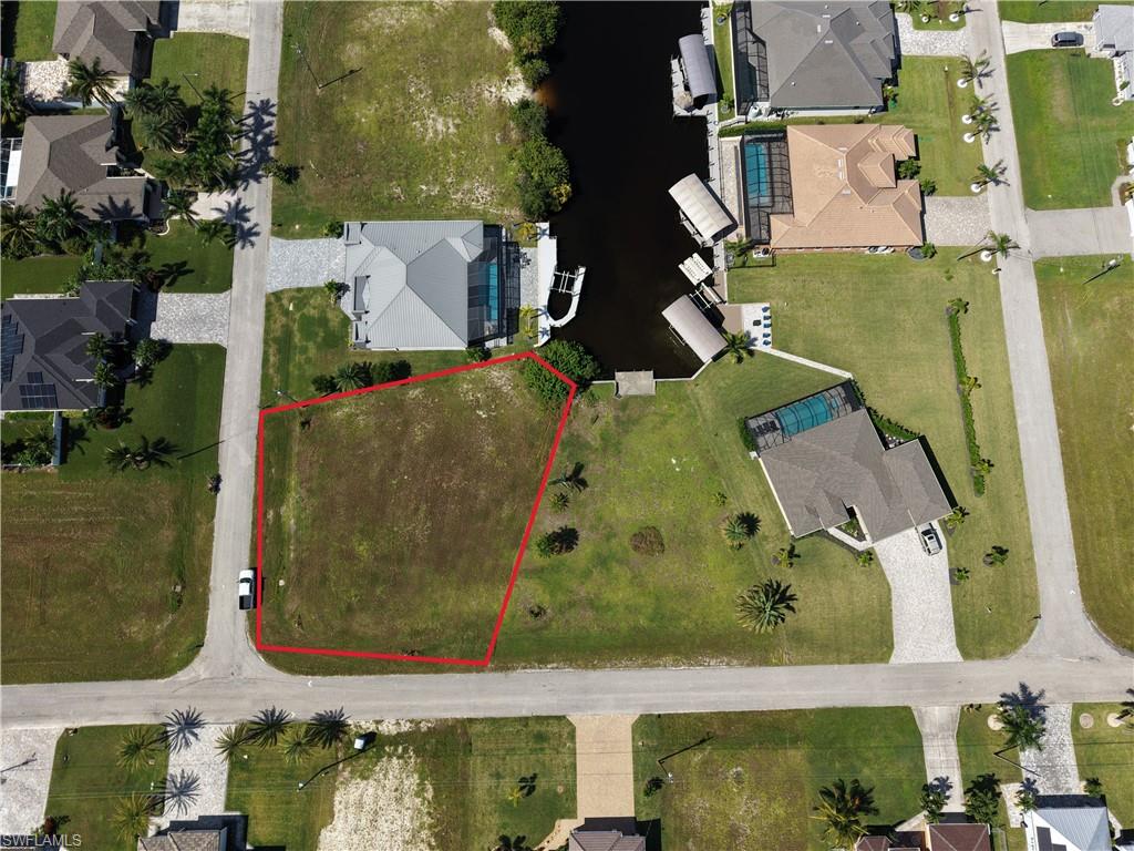 Vacant residential lot bordered by existing homes and paved streets