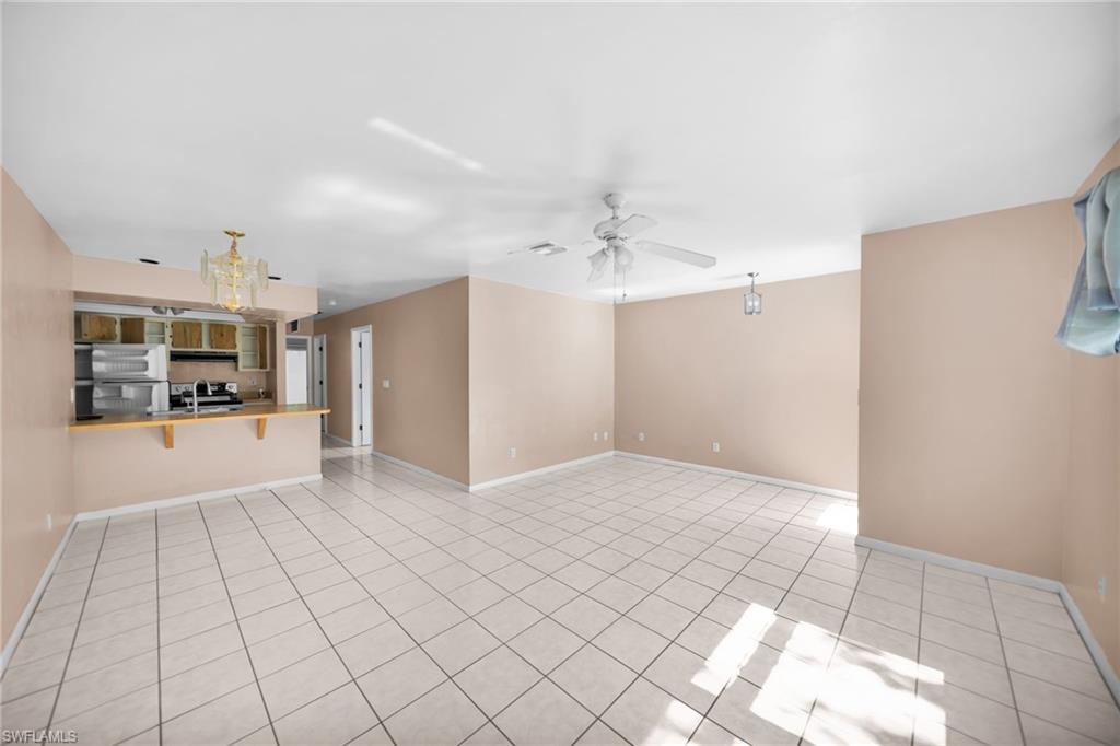 Open-concept living and dining area with ceramic tile flooring throughout, neutral wall finishes, and abundant natural light from multiple windows