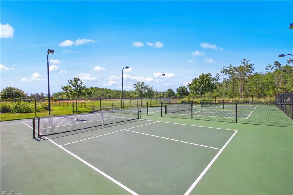 Professional tennis court complex featuring multiple regulation courts with white boundary markings, high-performance hard court surfaces in contrasting colors, perimeter fencing, and individual court lighting