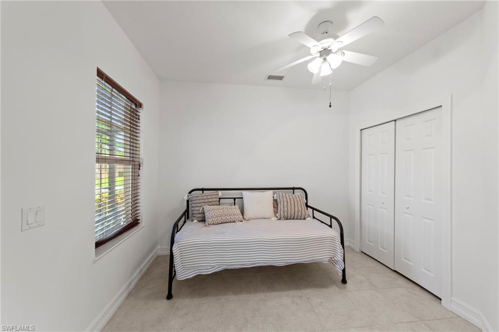Recessed window with wood-finish blinds, ceiling fan with integrated lighting, and bi-fold closet doors