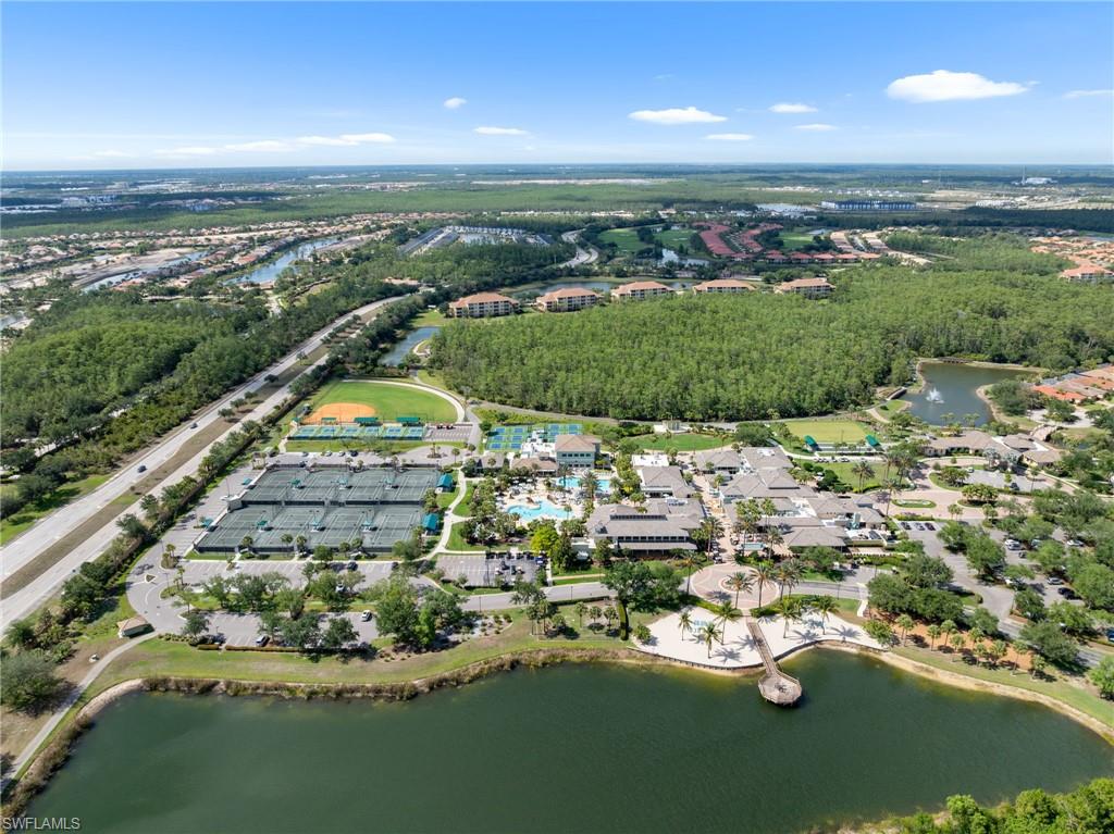 Aerial view showcasing a sprawling waterfront property with mature tree-lined grounds, multiple ponds, manicured landscaping, and direct water access