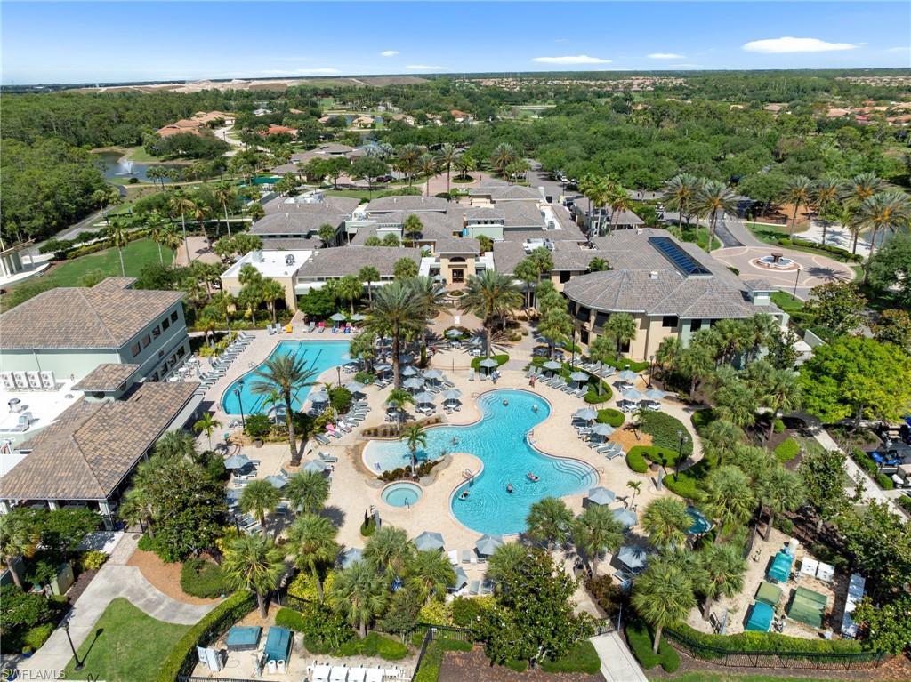 Resort-style resort amenity complex featuring multiple sparkling pools with integrated spa areas, mature landscaping throughout the expansive grounds, and multiple residential structures with dark architectural roofing set among lush tropical and native vegetation