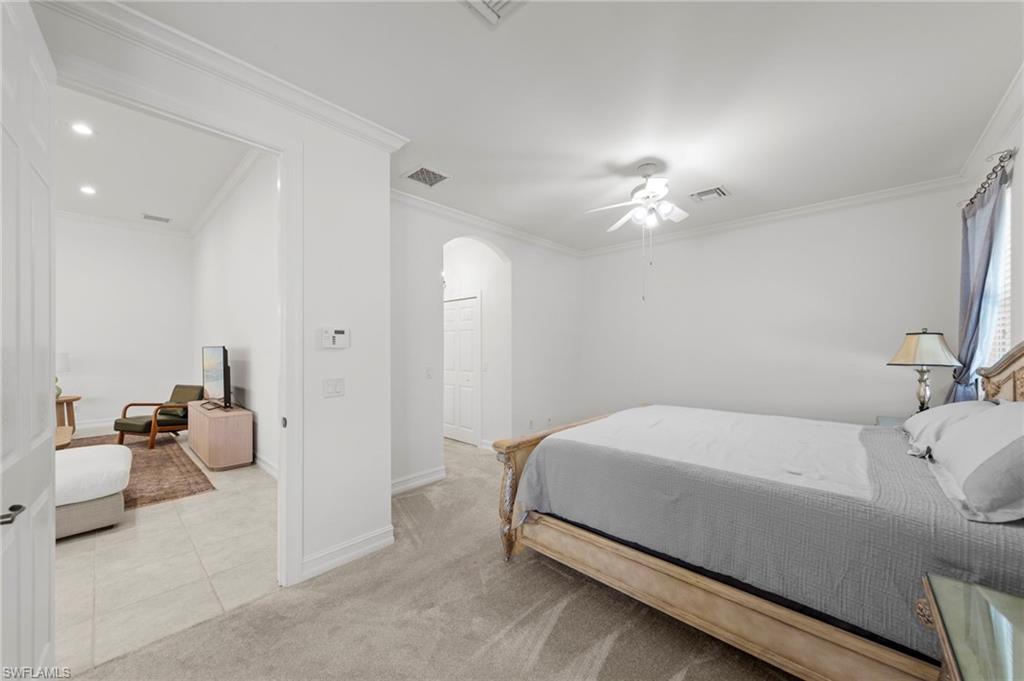 Primary Bedroom Suite featuring neutral wall finishes, wood-finish flooring, recessed lighting, and an ensuite bathroom with white cabinetry and tile flooring