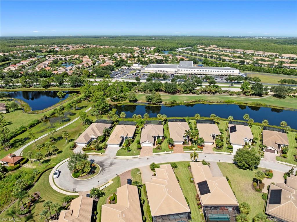 Aerial view showcasing this gated residential community featuring multiple single-story homes with tile roofing, manicured landscaping, and mature tree-lined streets