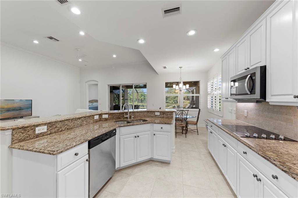 Kitchen featuring white cabinetry, stainless steel appliances, granite countertops, and recessed lighting