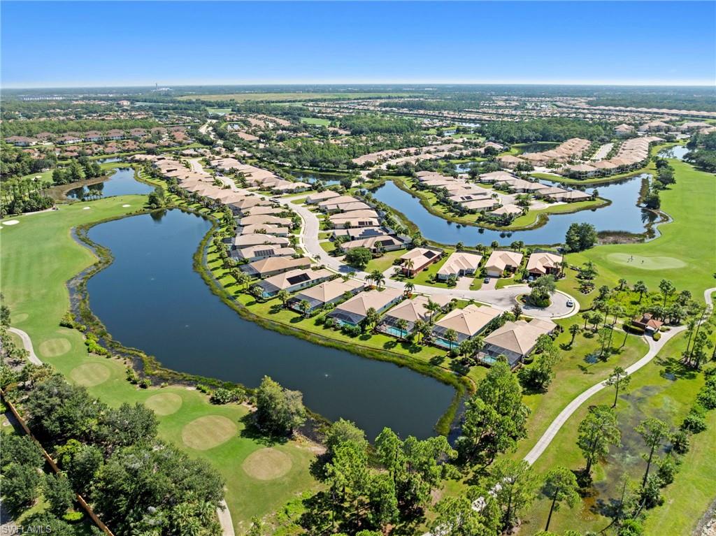Aerial view showcasing a sprawling residential community with multiple tree-lined lakes, lush green spaces, and curved street layouts throughout the neighborhood