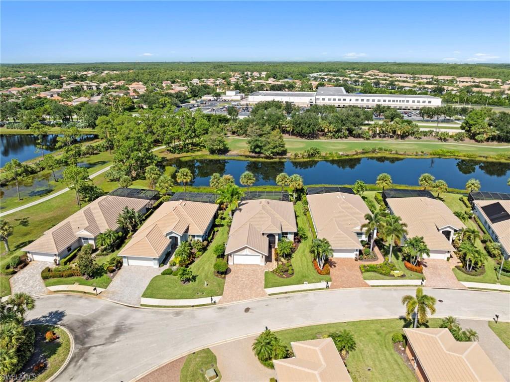 Aerial view showcasing multiple single-story residences with barrel tile roofing and concrete driveways, set on manicured lots with mature landscaping including palm trees and established greenery