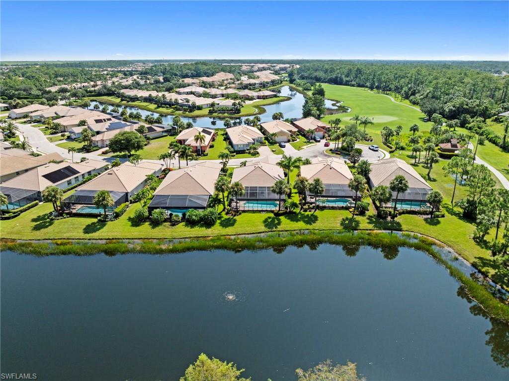 Waterfront community featuring elegant single-story residences with neutral-toned exteriors, manicured lawns, mature landscaping, and direct lakefront access along a serene water feature