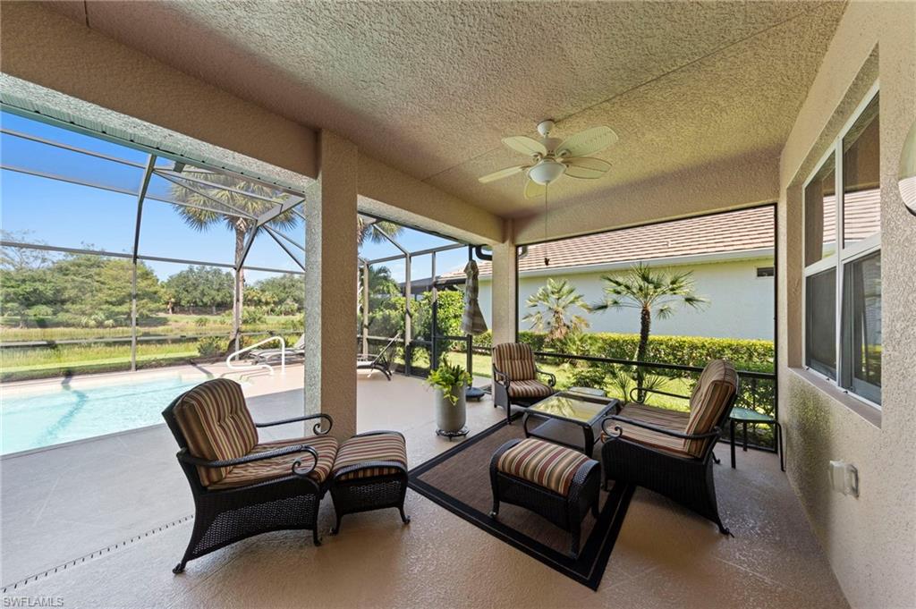 Screened lanai featuring a ceiling fan, direct access to a swimming pool, and a water feature beyond