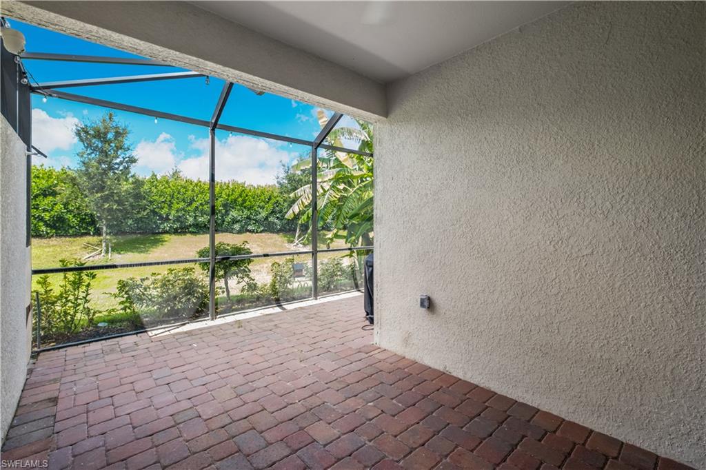 Screened patio with brick paver flooring and stucco exterior wall