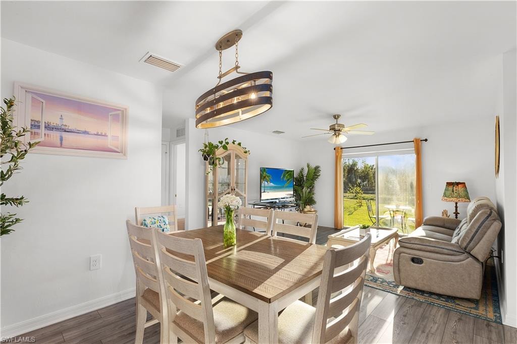 Open concept living area with wood-finish flooring, a contemporary ceiling light fixture, and a ceiling fan