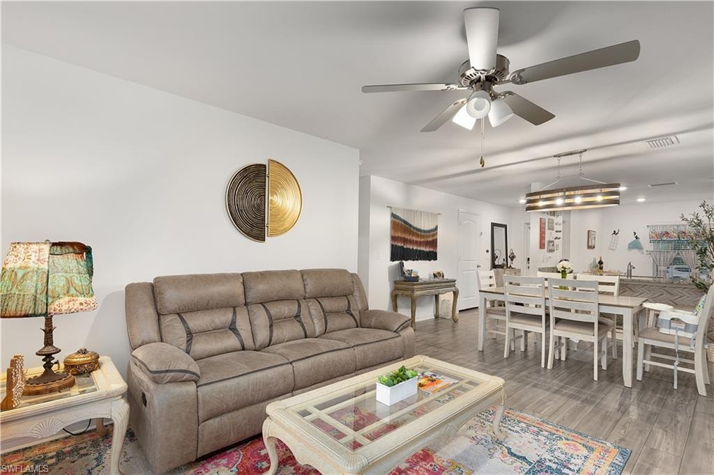 Recessed lighting, wood-finish flooring, and a ceiling fan with integrated lighting