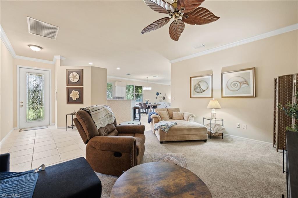 Vaulted ceilings with crown molding, ceiling fan, and tiled entry