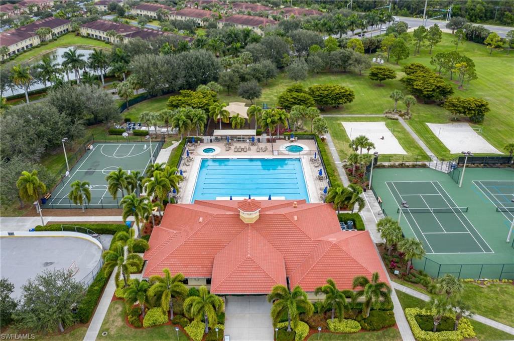 Resort-style aquatic center featuring an Olympic-length saltwater pool with dedicated lap lanes, surrounded by mature palm trees and tropical landscaping